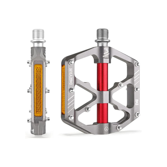 Silver and red alloy bicycle pedals with built-in reflectors, shown side by side on a white background.
