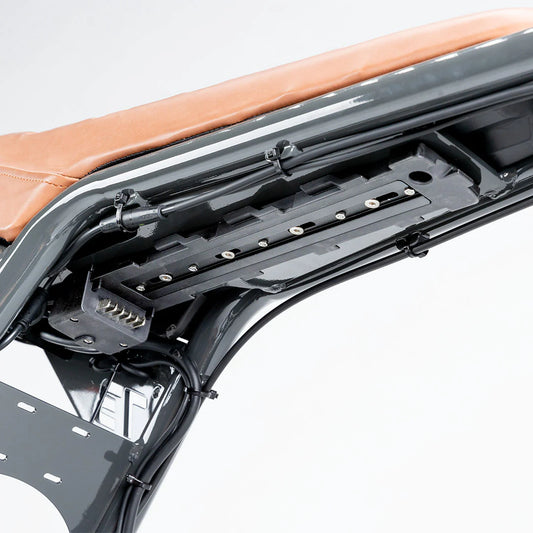 Close-up view of a battery mount plate designed for the Super73 Z Series Pro electric bike, showing mounting holes and metal construction.