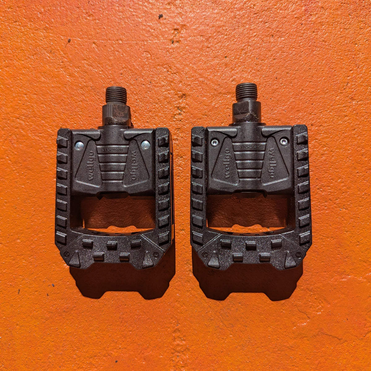 Folding nylon eBike pedal in a partially folded position, showing textured surface and metal hinge mechanism.