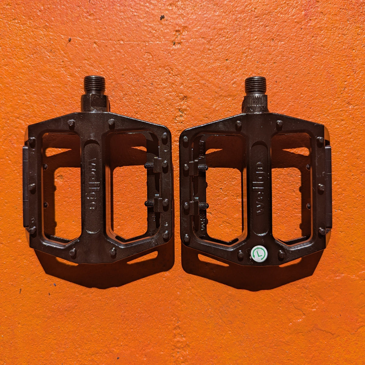 Close-up view of metal eBike pedals in Style 4, showcasing a sturdy, textured surface and durable construction.