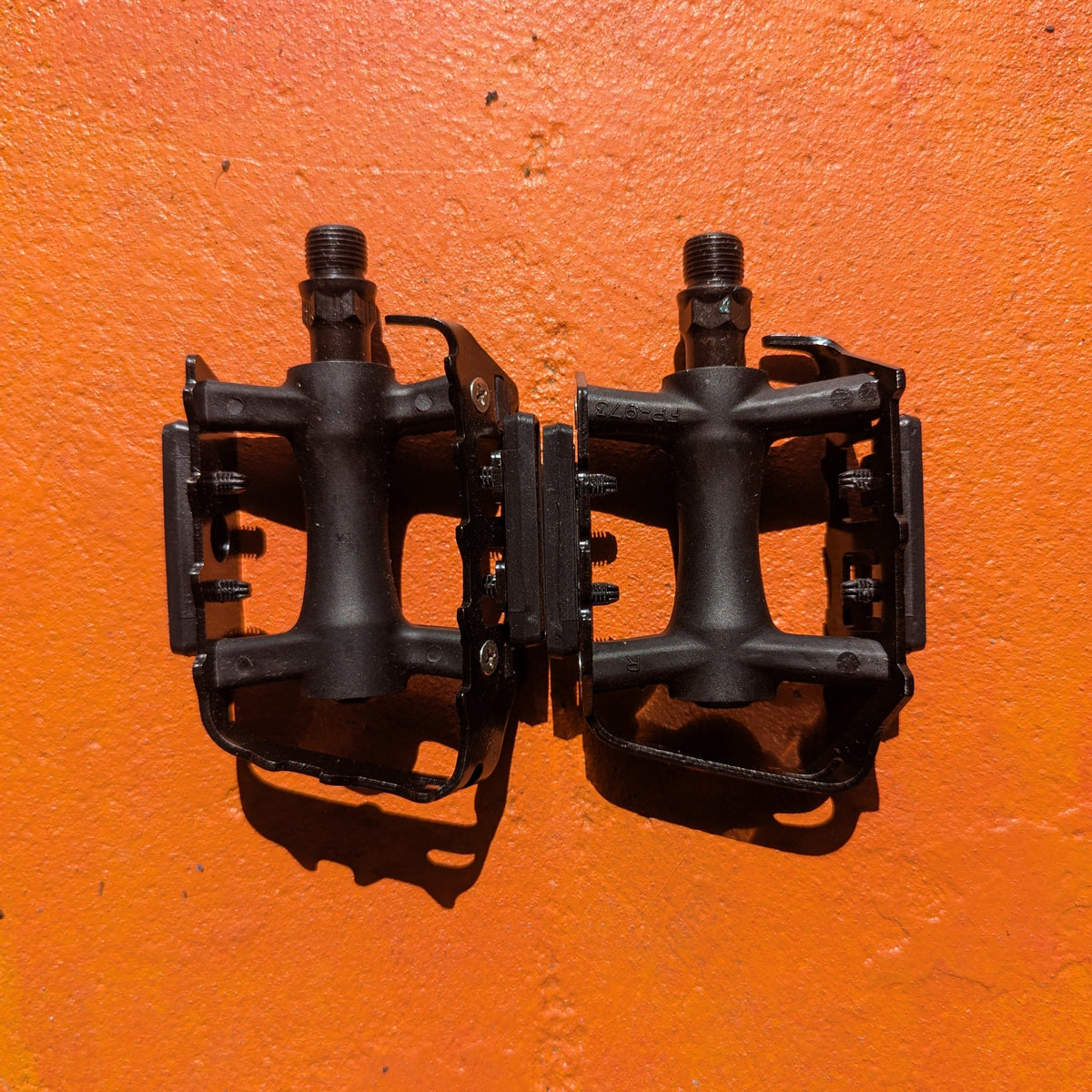 Close-up view of metal eBike pedals in Style 7, showcasing a sturdy, textured surface with a modern, angular design and reflective accents.