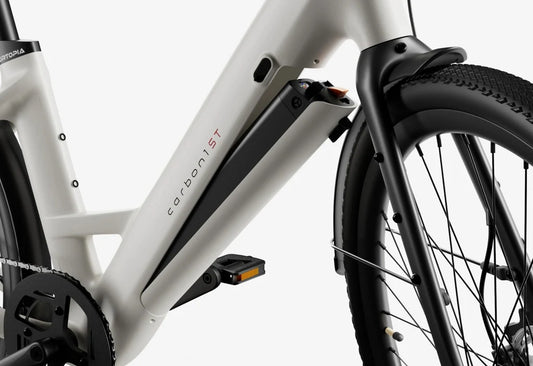 Side view of the Urtopia Carbon Classic Step Thru eBike in creme color, showcasing its lightweight carbon frame, step-through design, and sleek modern styling against a plain background.