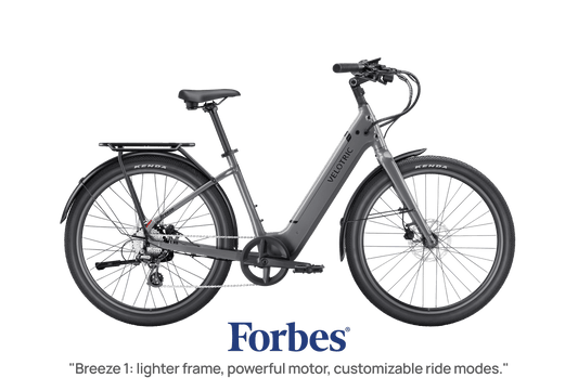 Slate gray Velotric Breeze 1 eBike side view, showcasing frame design and wheels against a plain background.