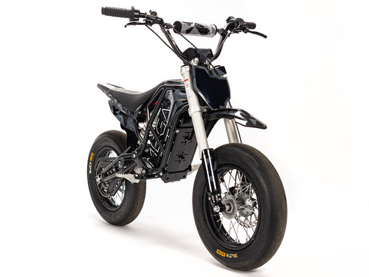 Stomp Ebox Megalith Graphics Kit displayed on a dirt bike, showcasing bold geometric patterns in black, white, and neon yellow with the Stomp logo on the side panels.